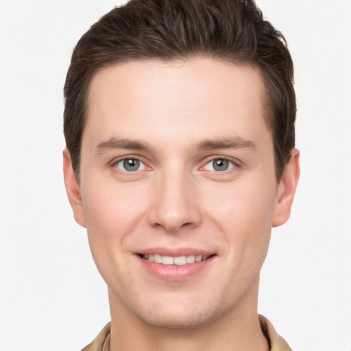 Joyful white young-adult male with short  brown hair and grey eyes