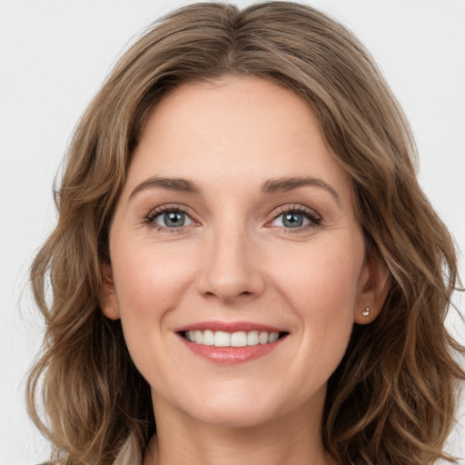 Joyful white young-adult female with long  brown hair and green eyes