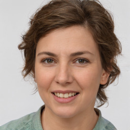 Joyful white young-adult female with medium  brown hair and green eyes