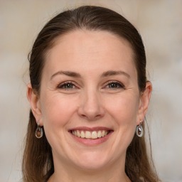 Joyful white adult female with medium  brown hair and grey eyes