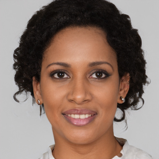 Joyful black young-adult female with medium  black hair and brown eyes