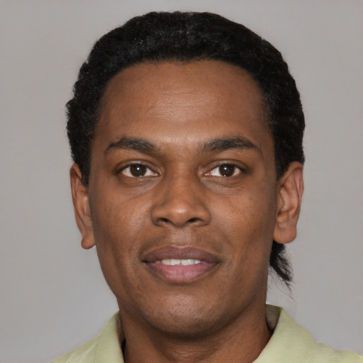 Joyful black young-adult male with short  black hair and brown eyes