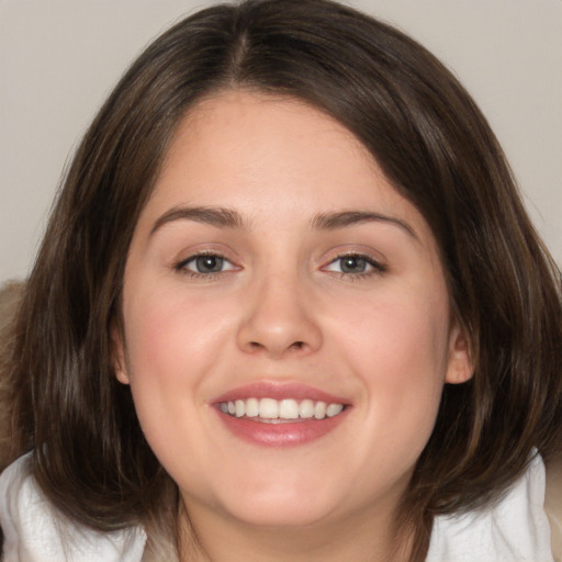 Joyful white young-adult female with medium  brown hair and blue eyes