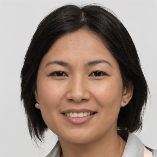 Joyful asian adult female with medium  brown hair and brown eyes