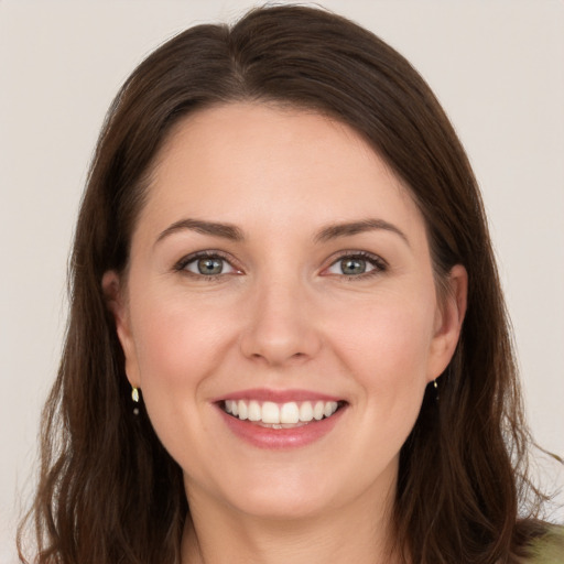 Joyful white young-adult female with long  brown hair and brown eyes