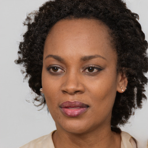 Joyful black adult female with long  brown hair and brown eyes