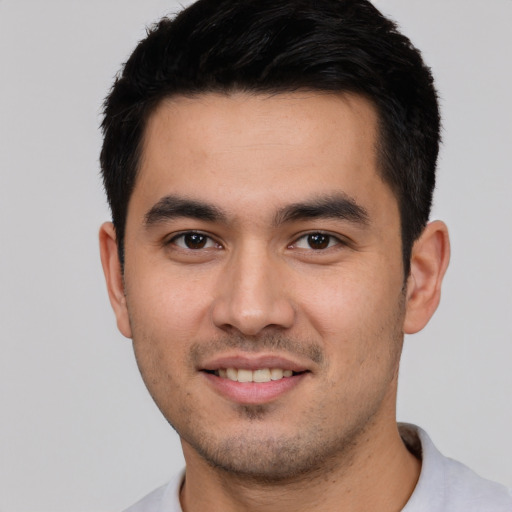 Joyful white young-adult male with short  black hair and brown eyes