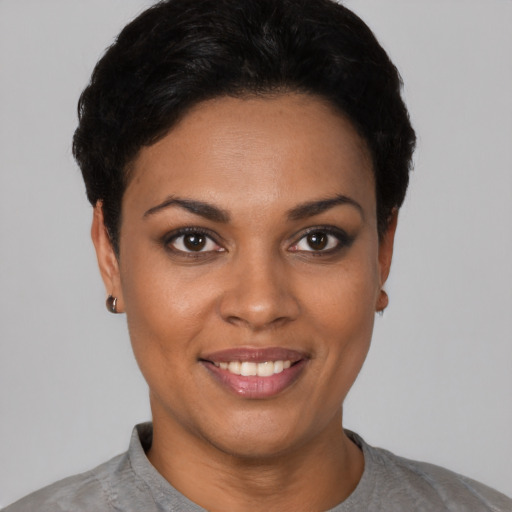 Joyful black young-adult female with short  black hair and brown eyes
