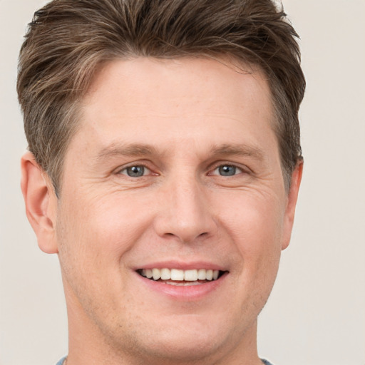 Joyful white adult male with short  brown hair and grey eyes