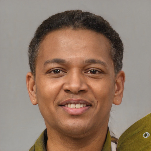 Joyful black young-adult male with short  brown hair and brown eyes