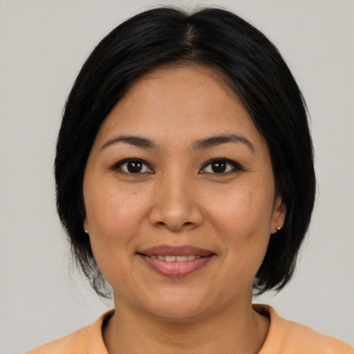 Joyful asian adult female with medium  brown hair and brown eyes