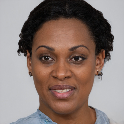 Joyful black adult female with short  black hair and brown eyes