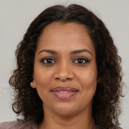 Joyful black young-adult female with medium  brown hair and brown eyes