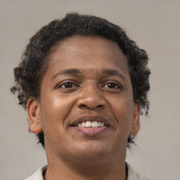 Joyful black young-adult male with short  brown hair and brown eyes
