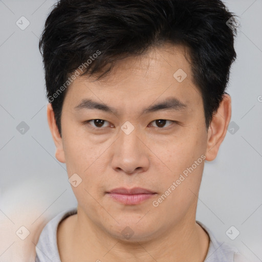 Joyful asian young-adult male with short  brown hair and brown eyes