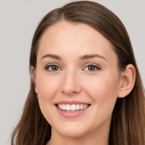 Joyful white young-adult female with long  brown hair and grey eyes