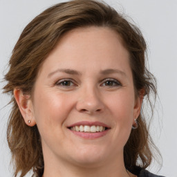 Joyful white young-adult female with medium  brown hair and grey eyes