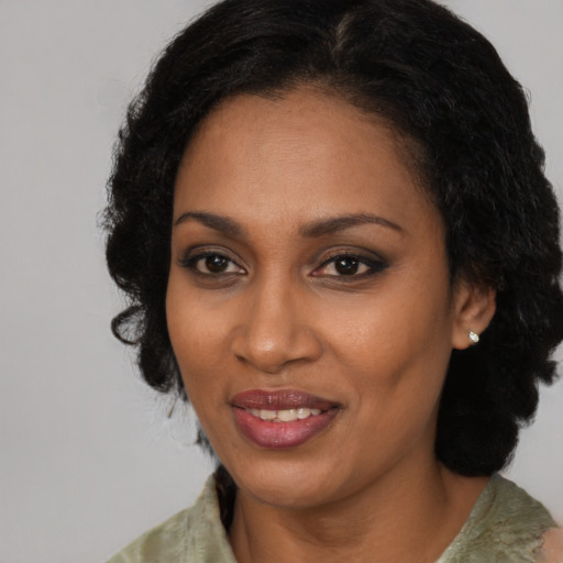 Joyful black adult female with medium  black hair and brown eyes
