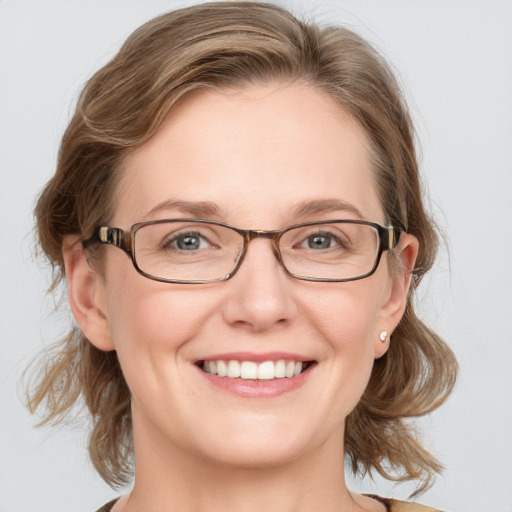 Joyful white adult female with medium  brown hair and blue eyes