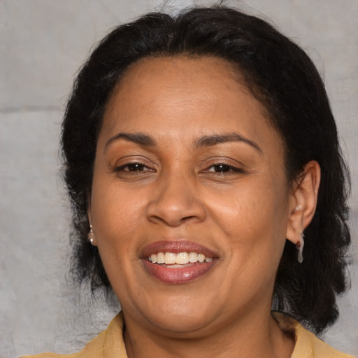 Joyful latino adult female with medium  brown hair and brown eyes