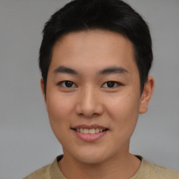 Joyful asian young-adult male with short  brown hair and brown eyes