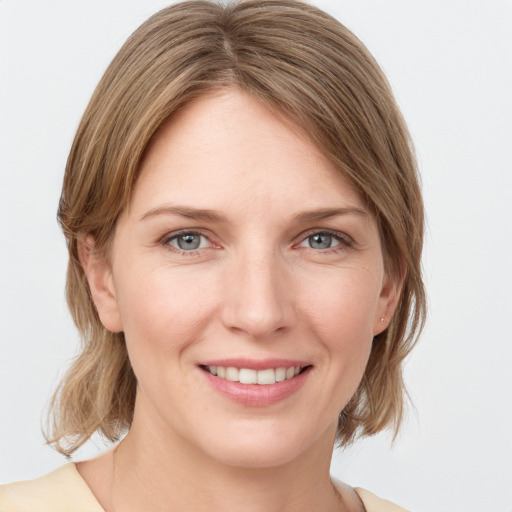 Joyful white young-adult female with medium  brown hair and blue eyes