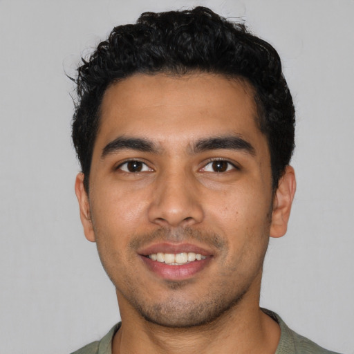 Joyful latino young-adult male with short  black hair and brown eyes