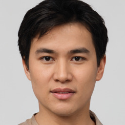 Joyful asian young-adult male with short  black hair and brown eyes