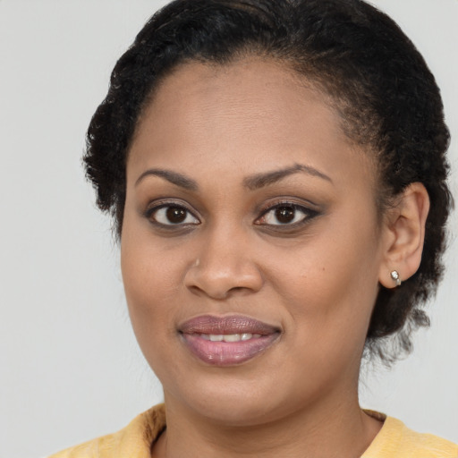 Joyful black young-adult female with medium  brown hair and brown eyes