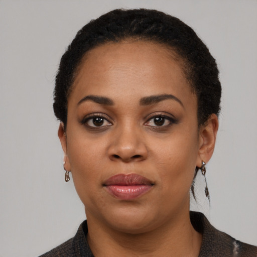 Joyful black young-adult female with short  black hair and brown eyes