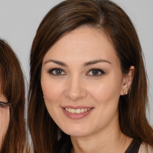Joyful white young-adult female with long  brown hair and brown eyes