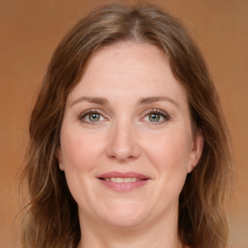 Joyful white adult female with medium  brown hair and green eyes