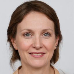 Joyful white adult female with medium  brown hair and grey eyes