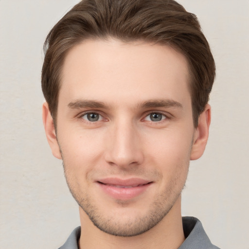 Joyful white young-adult male with short  brown hair and grey eyes