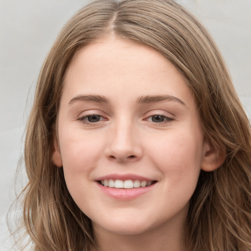 Joyful white young-adult female with long  brown hair and grey eyes