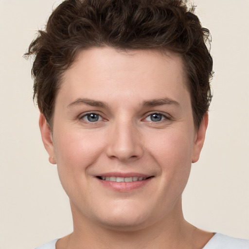 Joyful white young-adult female with short  brown hair and grey eyes