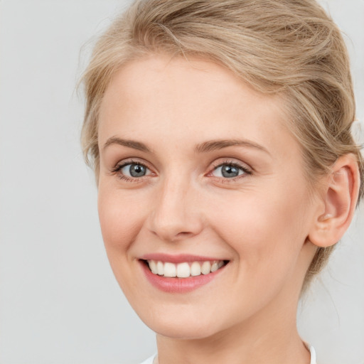 Joyful white young-adult female with medium  brown hair and blue eyes