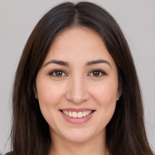 Joyful white young-adult female with long  brown hair and brown eyes