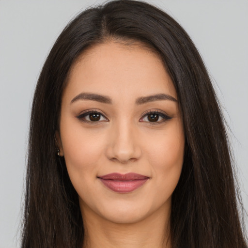 Joyful latino young-adult female with long  brown hair and brown eyes