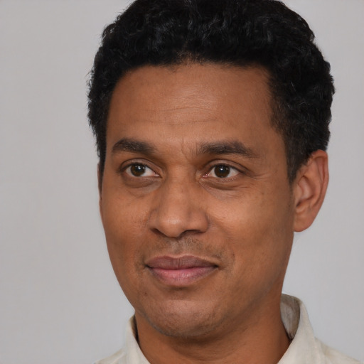 Joyful latino adult male with short  black hair and brown eyes