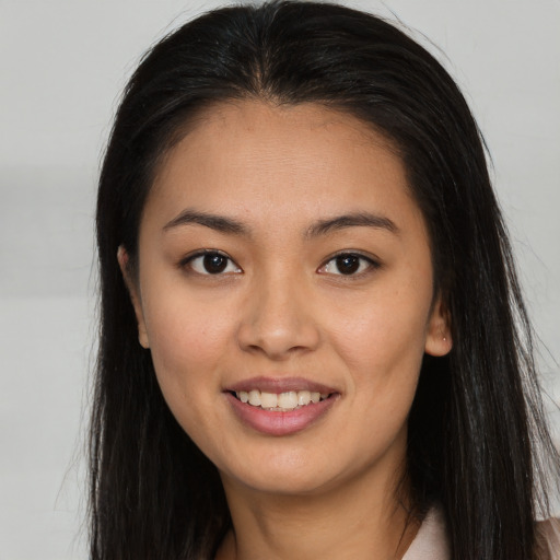 Joyful asian young-adult female with long  brown hair and brown eyes