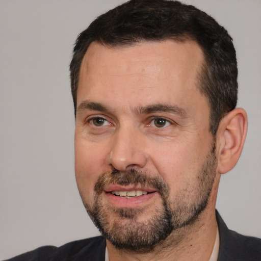 Joyful white adult male with short  black hair and brown eyes