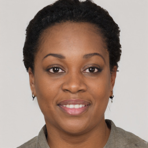 Joyful black young-adult female with short  black hair and brown eyes