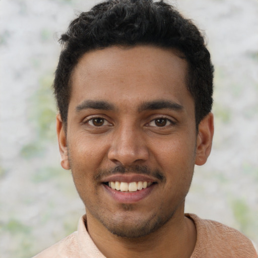 Joyful black young-adult male with short  black hair and brown eyes