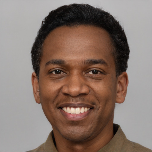 Joyful black adult male with short  black hair and brown eyes
