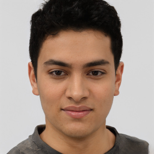 Joyful latino young-adult male with short  black hair and brown eyes
