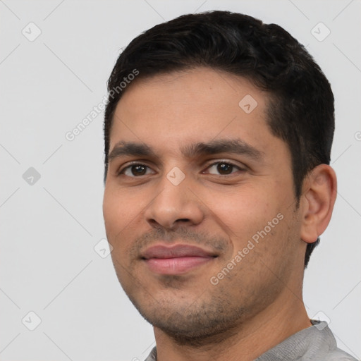 Joyful latino young-adult male with short  black hair and brown eyes