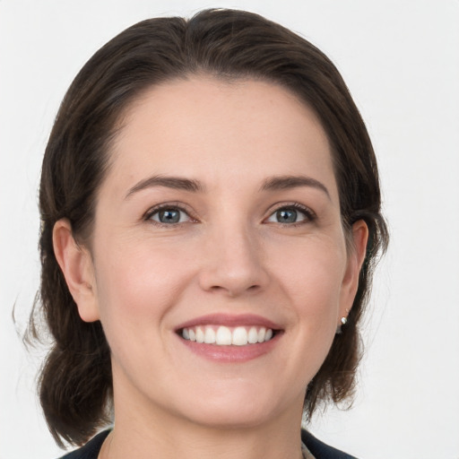 Joyful white young-adult female with medium  brown hair and grey eyes