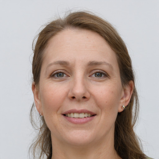 Joyful white adult female with long  brown hair and grey eyes