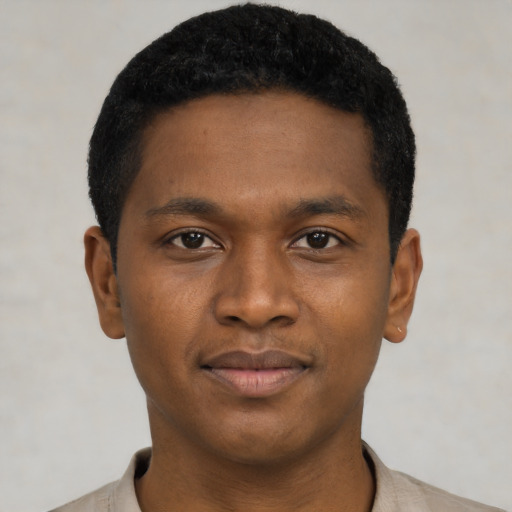 Joyful black young-adult male with short  black hair and brown eyes